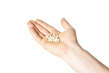 pills in male hand closeup on white background