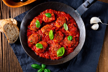 Baked mini meatballs in tomato sauce with basil