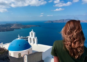 chica joven mirando paisaje de las islas griegas junto a cúpula azul