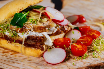 Sandwich with meat, fresh salad and vegetables cherry tomatoes, radish, onions, cheese, sauce