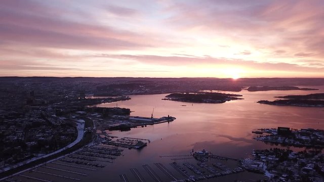Aerial slowly approaching shot towards Aker Brygge and Oslo center at sunset