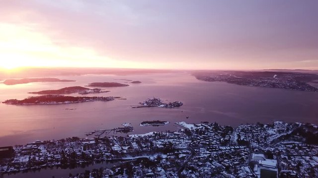 Rotating to the left aerial shot over Oslofjord towards Aker Brygge and city center at the sunset in Oslo, Norway