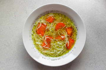 Chicken soup with carrot and dill, view from above