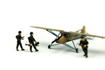 Miniature people : team soldier standing together with army tank and aircraft air combat using for Toy Soldier Day concept.
