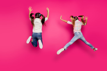 Full length body size rear back behind view of two crazy cheerful cheery positive pre-teen girls...