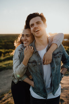 Lachendes umarmendes Paar bei Sonnenuntergang 