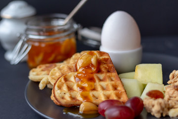 apricot jam with almonds and hazelnuts. golden homemade fresh waffles. boiled egg. breakfast business women. high protein content.