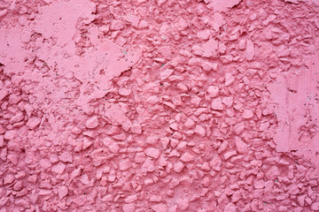 Concrete wall texture. Uneven peeling surface painted pink. Perfect for background and design.