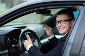 Fototapeta na wymiar smiling businessman showing the key of his new car
