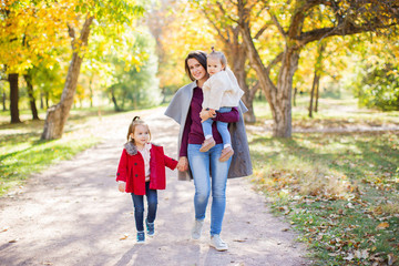 Fototapeta premium Mother with two kids outdoors.