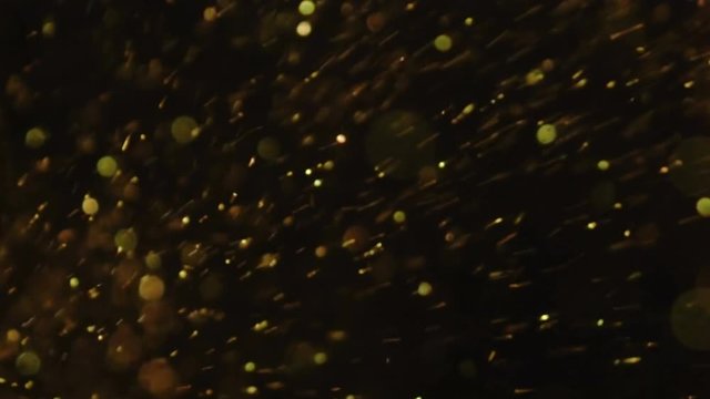Luxury Glitter bokeh out of focus glitternig particles sparks splash in camera on black background fashion footage for your special events projects. (You can drag and drop to use screen blending mode)