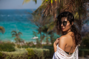 Young Beautiful Woman in swimsuit and sunglasses Relaxing at the Beach