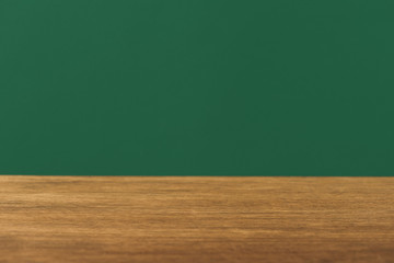 empty wooden table on green background with copy space