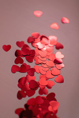 Red hearts. Heart confetti on coral background, glitter background. Color of the year 2019 - living coral.