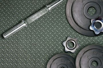 Obraz na płótnie Canvas Dumbbells and weights are lying on the floor in the gym. Barbell set and gym equipment. Metal loads in the fitness club