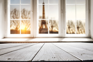 Table background of free space for your decoration. White wooden window space. Sunset time and Paris city landscape. 