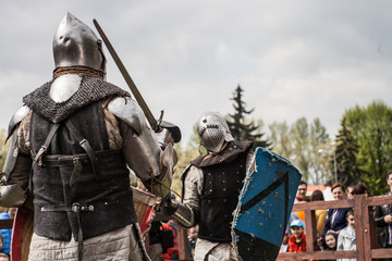 Knight tournament. The knights in the congregations are fighting in the ring. Public event in the...