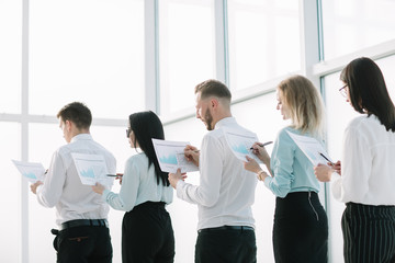close up. employees with financial reports, standing in line.