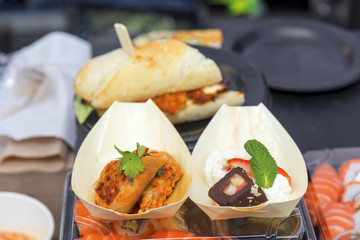 Selection of fast food. Asian street food market. Salmon sushi, asian pork burger Sloppy Joes, chicken with vegetable and sweet fruit style sushi, rice, strawberry, chocolate and coconut.