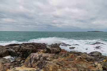 sea ​​scenery in dramatic weather in the blue hour. a landscape with dramatic clouds and stormy water that breaks down on the shore and the rocks.