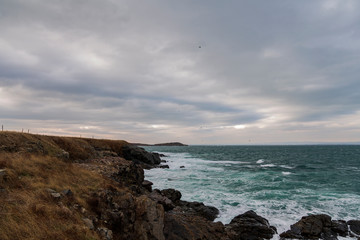 sea ​​scenery in dramatic weather in the blue hour. a landscape with dramatic clouds and stormy water that breaks down on the shore and the rocks.