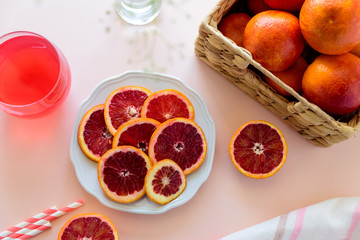 Glass of fresh blood orange juice on pink background. Selective focus