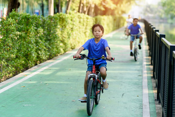 Obraz premium Preteen boy ride a bicycle in a park