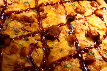 Close up view on a tasty Pizza with meat, cheese, corn, onions and ketchup sauce
