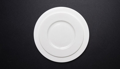 Empty white plates on black color background,