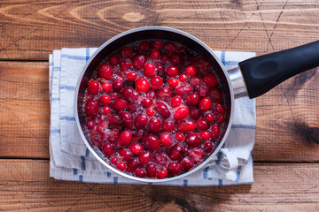Step by step preparation of cranberry juice, step 3 - cooking juice, top view, selective focus