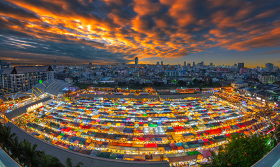 Sunset over Bangkok city business downtown and train night market Ratchada.