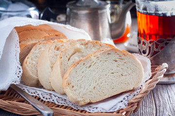 Homemade white bread in a rustic style, sliced, horizontal
