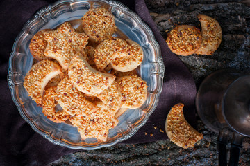 Shortbread with chopped hazelnuts on a metal platter, top view, horizontal
