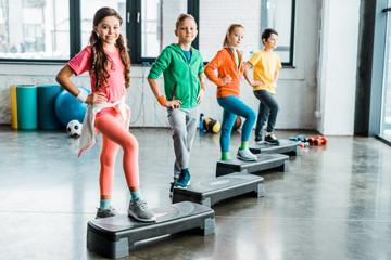 Group of kids using step platforms in gym