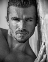Vertical portrait of a handsome caucasian male model posing on the beach