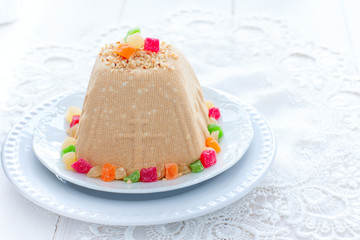 Traditional curd Easter with boiled condensed milk, nuts and candied fruits on a white holiday table, horizontal, copy space