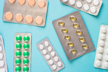 Tablets and vitamin on a blue background.