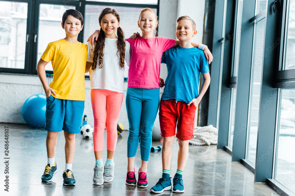 Wall mural Preteen kids embracing after training in gym