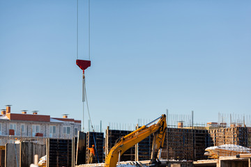 the boom of the crane lowers the concrete slab at the construction site of a residential building. Safety, the stages of construction.