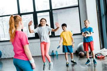 Inspired kids jumping with skipping rope in gym