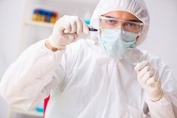 Naklejka premium Young expert criminologist working in the lab