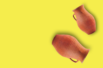 Pair of antique clay brown weathered and scratched vases with handles on yellow table with copy space for your text. Archeology excavations concept