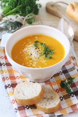 Vegetable carrot cream soup with parsley and grated cheese