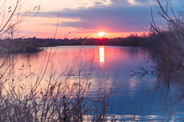 Sunset or sunrise on the cloudy sky on lake