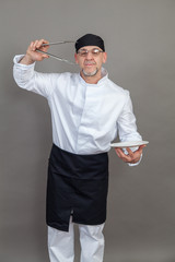 Elderly chef on grey background, isolated, concept