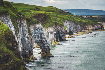 Close-up green covered cliff. Northern Ireland shoreline. Overwhelming overview of the Irish bay....