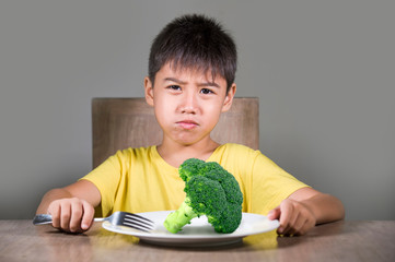 disgusted child refusing to eat healthy green broccoli feeling upset in kid nutrition education on...