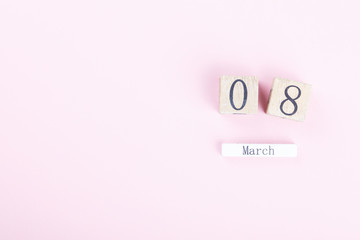 Wooden block calendar International of March 8 on a pink background. Womens Day, is celebrated every year.Holiday concept.Flat lay, top view, copy space