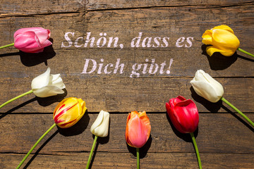 Grußkarte mit Tulpen auf Holz mit dem Satz Schön, dass es dich gibt