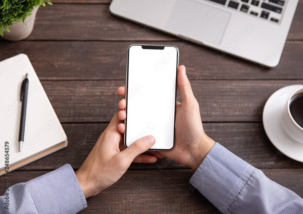 Poster man using blank smartphone on workplace desk